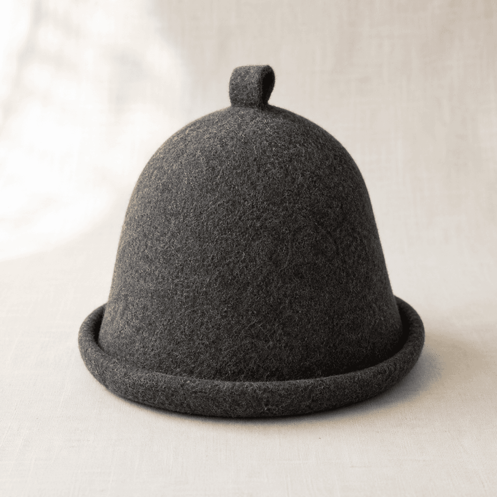 Savu charcoal wool felt sauna hat on a warm off-white background